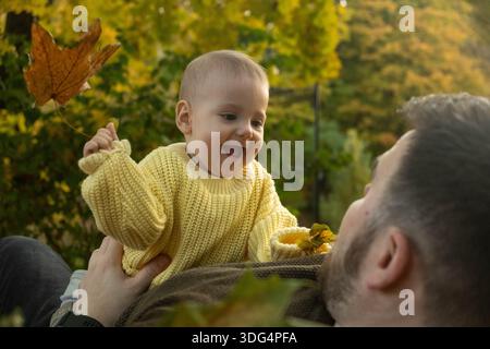 Vater und Baby genießen Herbstlaub Stockfoto