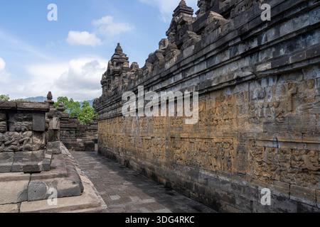 Blick auf die Landschaft der Galerie oder des Korridors mit Basreliefs aus Stein im zum UNESCO-Weltkulturerbe gehörenden Borobudur alten buddhistischen Tempel, Magelang, Java, Indonesien Stockfoto