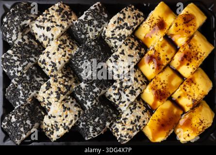 Eine detaillierte Aufnahme einer Reihe japanischer Sushi-Brötchen mit Sesam. Stockfoto