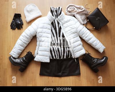 Stylisches Damenoutfit für Herbst und Winter. Stylisches Winter-Outfit mit gedämpfter Jacke und Kampfstiefeln, Pullover, Mütze und Accessoire. Draufsicht Stockfoto