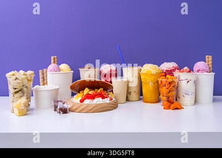 Die kühle Cremigkeit eines Beeren-Smoothies steht im Kontrast zum leichten Brausen hausgemachter Limonade und knusprigem Avocadotoast. Stockfoto