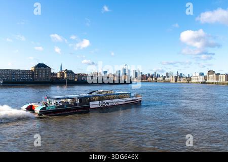 London, England - 30. November 2025; Panoramablick auf die Hochgeschwindigkeits-Passagierfähre Uber-Boot von Thames Clippers auf der Themse mit der Stadt in der Stockfoto