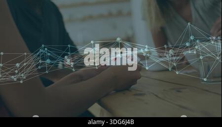 Die Hände fächern, die Spielkarten zu Hause auf einem Holztisch halten, mit Netzwerküberlagerung und Glas Stockfoto