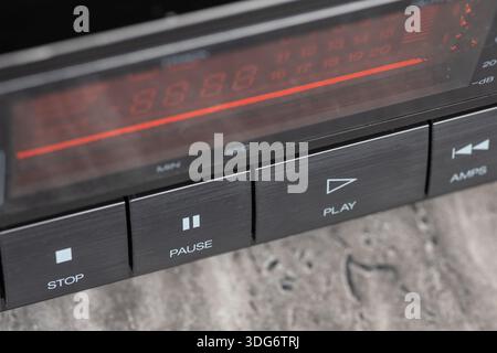 Das klassische Armaturenbrett des CD-Players verfügt über ein rotes Digitaldisplay, Funkbedienelemente und metallische Tasten. Diese Retro-Stereoanlage ruft Nostalgie und Mitternacht hervor Stockfoto