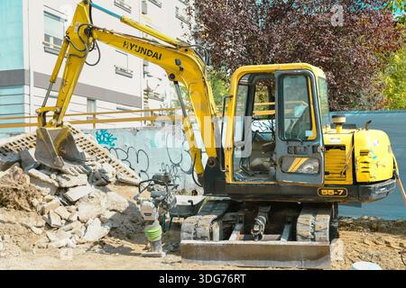 Ein Hyundai Minibagger, der auf einer städtischen Baustelle arbeitet, umgeben von Schutt und Abbruchschutt Stockfoto