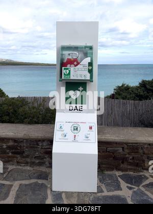 Stintino, Sassari Italien: Öffentliche automatisierte externe Defibrillatorstation (AED DAE), die entlang eines Küstenweges mit Blick auf das Meer installiert ist. Stockfoto