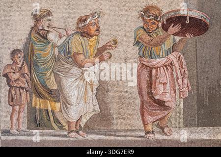 NEAPEL, ITALIEN – 26. JUNI 2025: Mosaikdetail mit Straßenmusikern aus Pompeji im Archäologischen Museum von Neapel, in dem Roman d Stockfoto