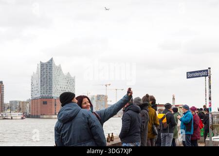 Hamburg Deutschland - 21. Februar 2020. Eine Frau, die ein Selfie oder Foto mit einer Kamera am Aussichtspunkt des Hafens macht. Elbphilharmonie und Skyline der Stadt in der BA Stockfoto