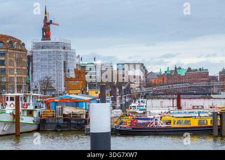 Hamburg Deutschland - 21. Februar 2020. Hafenszene am Binnenhafen. Arbeitsboote und Lastkähne angedockt. St. Catherines Church Tower mit Gerüsten im bac Stockfoto
