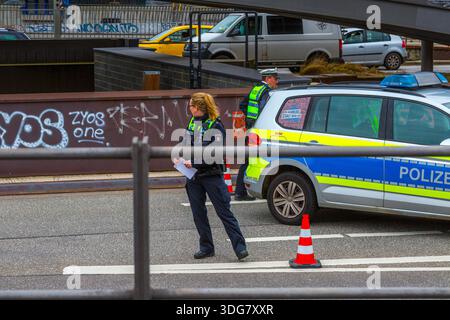 Hamburg – 21. Februar 2020: Polizistin steht freitags in der Nähe eines Streifenwagens, der die Straße unter der Baumwallbrücke blockiert Stockfoto