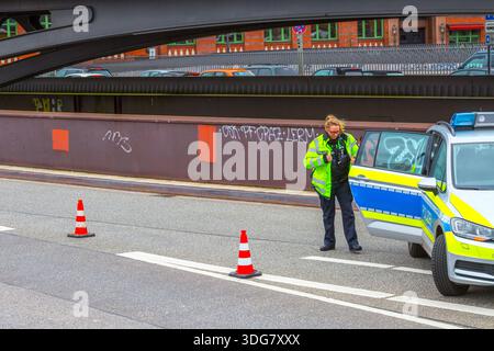 Hamburg – 21. Februar 2020: Polizistin öffnet freitags die Tür eines Streifenwagens, der die Straße in der Nähe der Speicherstadt blockiert Stockfoto