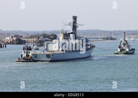 Schlepper begleiten die Royal Navy Fregatte HMS ARGYLL (F231) zu einem Liegeplatz in der Marinebasis Stockfoto