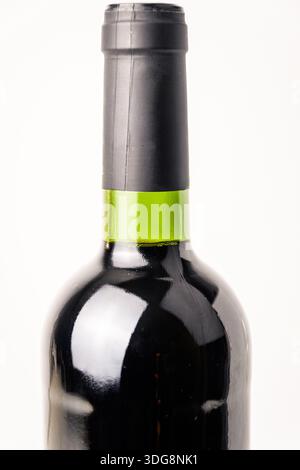 Makronaht eines Halses einer dunklen Weinflasche mit schwarzer Kapsel und grünem Glasring, isoliert auf weiß für Verpackungs- und Branding-Konzepte. Stockfoto