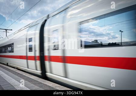 Dynamischer Schuss eines vorbeifahrenden deutschen EISZUGES. Symbol für modernen Schienenverkehr, Hochgeschwindigkeitsverkehr und Reisen in Deutschland. Professionelle Bewegungsunschärfe Stockfoto