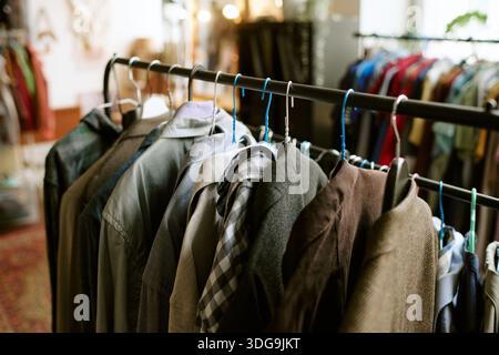 Verschiedene Second-Hand-Kleidung, die auf einem Rack im Thrift Store aufgehängt wird Stockfoto