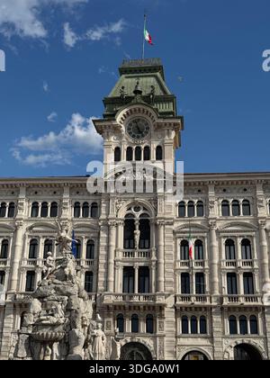 Das Rathaus von Triest, Italien, steht stolz auf der Piazza Unità d’Italia mit seinem kunstvollen Uhrenturm und dem kunstvollen Brunnen Stockfoto