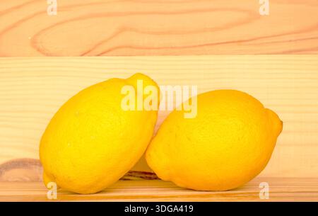 Frische saftige gelbe Zitronen auf hölzernem Hintergrund, Makro. Stockfoto