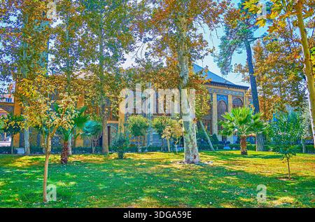 Die Gebäude von Emarat-e Badgir (Windtürme) und Talar-e Almas (Diamantenhalle) sind hinter den Bäumen des Golestan Gartens, Teheran versteckt? ???? Stockfoto