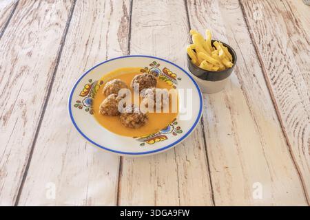 Ein Eintopf aus Fleischbällchen mit Kichererbsen und in Scheiben geschnittenen ​​carrots, alle in einem großen Auflauf gekocht, die Sauce überzieht alle Zutaten Stockfoto