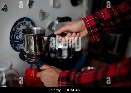 Bereiten Sie Kaffee mit einem Topf auf einem Herd zu Stockfoto