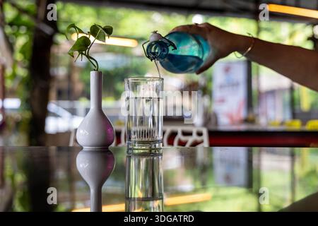 Erfrischendes Wasser wird aus der Flasche in Nahaufnahme gegossen Stockfoto