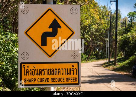 Thailand, Koh Mak, fahren, zweisprachige scharfe Kurve, Geschwindigkeitswarnung Stockfoto