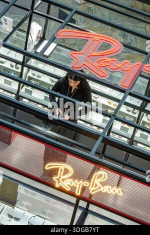 Junge Frau, die an einem Ray Ban Sonnenbrillenstand im West Quay Einkaufszentrum in Southampton, Hampshire, Großbritannien arbeitet Stockfoto