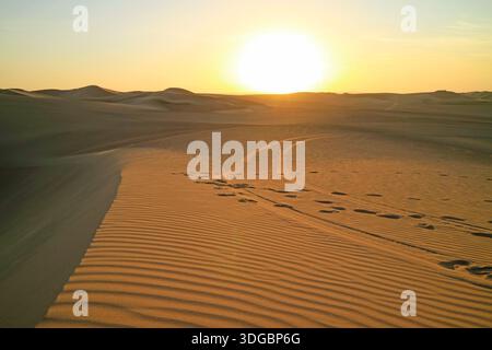 Dünenspuren und Fußspuren auf den Sanddünen der Wüste Huacachina bei Sonnenuntergang, Region Ica, Peru, Südamerika Stockfoto
