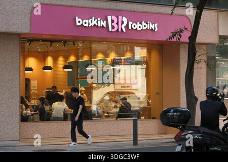 Das Äußere der Eisdiele Baskin Robbins mit Blick auf das Innere durch Glasfenster, die zwanglose Restaurants und Geschäfte auf der Straße zeigen Stockfoto