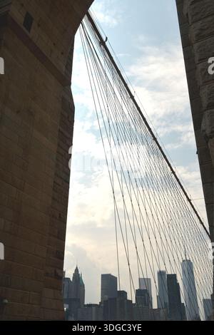 Die 1883 erbaute Brooklyn Bridge ist die erste Hängebrücke aus Stahl und überblickt die Wolkenkratzer von Manhattan, den Big Apple. Stockfoto