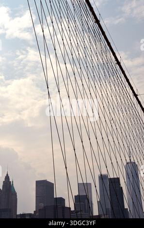 Die 1883 erbaute Brooklyn Bridge ist die erste Hängebrücke aus Stahl und überblickt die Wolkenkratzer von Manhattan, den Big Apple. Stockfoto