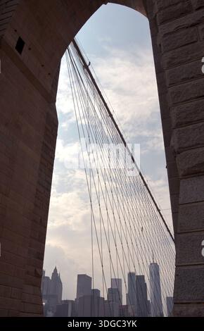 Die 1883 erbaute Brooklyn Bridge ist die erste Hängebrücke aus Stahl und überblickt die Wolkenkratzer von Manhattan, den Big Apple. Stockfoto