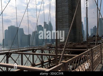 Die 1883 erbaute Brooklyn Bridge ist die erste Hängebrücke aus Stahl und überblickt die Wolkenkratzer von Manhattan, den Big Apple. Stockfoto