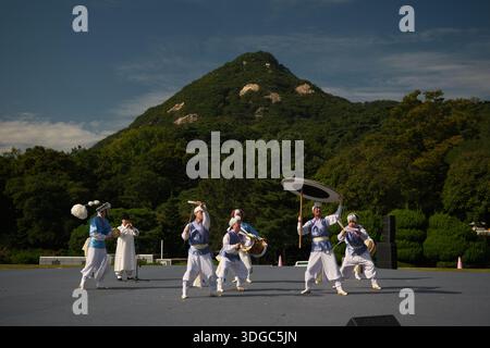 Seoul, Südkorea: Traditionelle koreanische Percussion-Gruppe mit samulnori-Tanz mit Schlagzeug und Hüten vor Bergkulisse Stockfoto