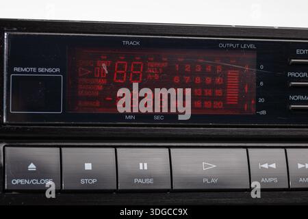 Das klassische Armaturenbrett des CD-Players verfügt über ein rotes Digitaldisplay, Funkbedienelemente und metallische Tasten. Diese Retro-Stereoanlage ruft Nostalgie und Mitternacht hervor Stockfoto
