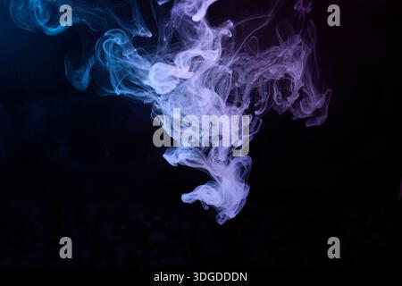 Farbenfrohe Rauchwolken, die leuchtend blau und violett Gas wirbeln Stockfoto