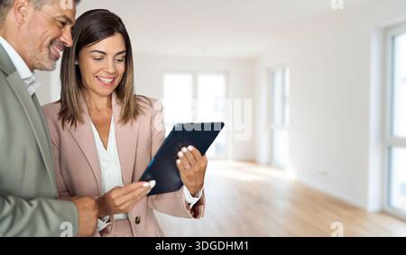 Broker mit Tablet, der Kunden Investoren neue Möglichkeiten für Investitionen in Immobilien zeigt. Stockfoto