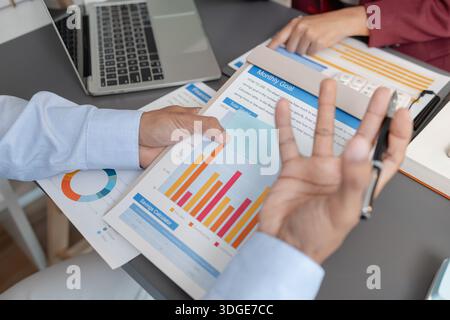 Geschäftskollegen prüfen gemeinsam Budgetdiagramme in einem modernen Büro und konzentrieren sich dabei auf finanzielle Erkenntnisse, Leistungskennzahlen und strategische Planung Stockfoto