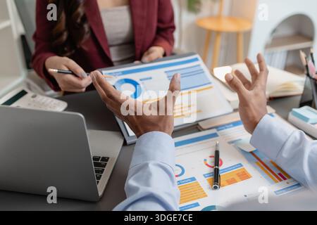 Geschäftskollegen prüfen gemeinsam Budgetdiagramme in einem modernen Büro und konzentrieren sich dabei auf finanzielle Erkenntnisse, Leistungskennzahlen und strategische Planung Stockfoto