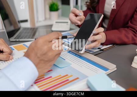 Geschäftskollegen prüfen gemeinsam Budgetdiagramme in einem modernen Büro und konzentrieren sich dabei auf finanzielle Erkenntnisse, Leistungskennzahlen und strategische Planung Stockfoto