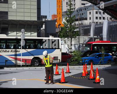TOKIO, JAPAN - 11. April 2023: Arbeiter an der Front von Yanmar Tokio unter Arbeiter in einer Wiege, die das Gebäude reinigen. Stockfoto