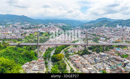 Atemberaubende Aussicht auf die Pereira-Brücke, die städtische Gebiete in Risaralda, Kolumbien, mit üppiger grüner Umgebung verbindet. Stockfoto