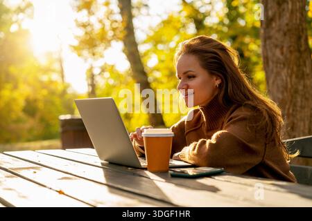 Stadträtin mit Laptop auf dem Tisch im Stadtpark Stockfoto