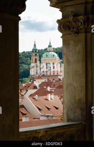 Ein malerischer Blick auf die Nikolaikirche und die historischen Paläste in Malá Strana, Prag, vom Schlosspark unter der Prager Burg aus gesehen. Stockfoto