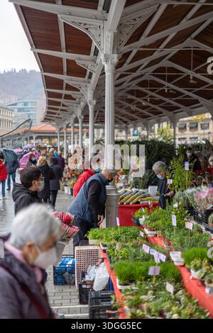 Bilbao, Spanien – 21. November 2021: Eine Menge von Einkäufern, viele von ihnen Senioren, tragen Schutzmasken, während sie im geschäftigen Merca in Topfpflanzen stöbern Stockfoto