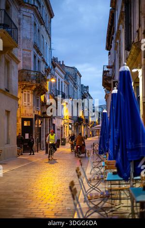 Bordeaux, Frankreich - 23. November 2021: Abendliche Straßenszene auf der Rue du Ha, einer Straße, die nur für Fahrräder genutzt wird, mit beleuchteten Straßenlaternen, mit Radfahrern und Fußgängerzonen Stockfoto