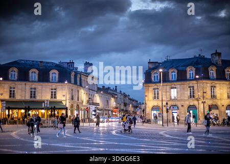 Bordeaux, Frankreich - 23. November 2021: Abendlicher Blick auf den Place de la Victoire mit ebenerdiger Beleuchtung auf dem Kopfsteinpflasterplatz mit beleuchtetem Café Stockfoto