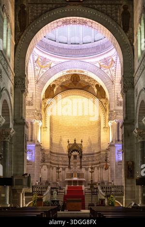 Innenansicht der Basilika Saint Martin in Tours France mit hoch bemalten Bögen und einer Kuppel über dem Hauptaltar mit einem roten Teppich, der eine Mutter schafft Stockfoto