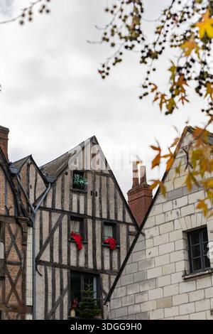Historisches Fachwerkhaus mit Holzbalken und roten Backsteinen steht neben einem weißen Steingebäude mit Schieferdach in Tours France, das eine schöne Schönheit schafft Stockfoto