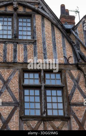 Nahaufnahme der historischen Fachwerkhausfassade mit rotem Ziegelsteinmauerwerk mit Fischgrätenmuster und Holzbalken in Tours France, die eine wunderschöne Landschaft schaffen Stockfoto